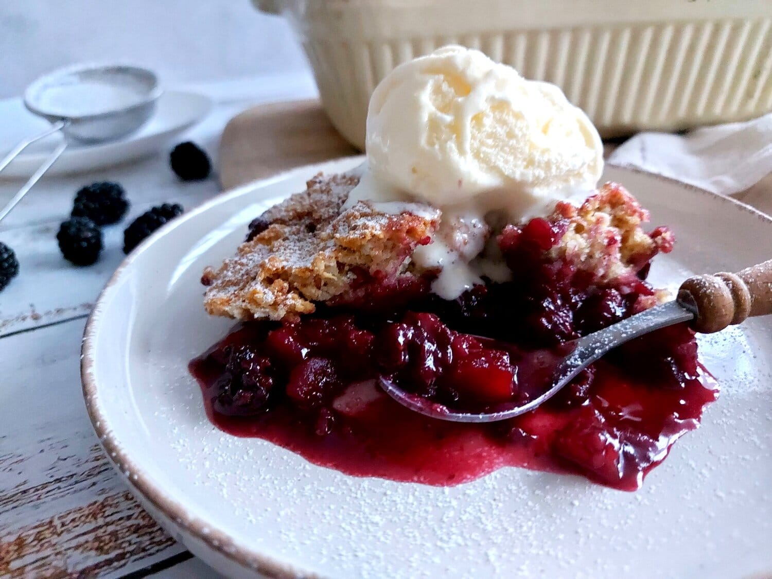 Blackberry Cobbler on a white plate with a spoon