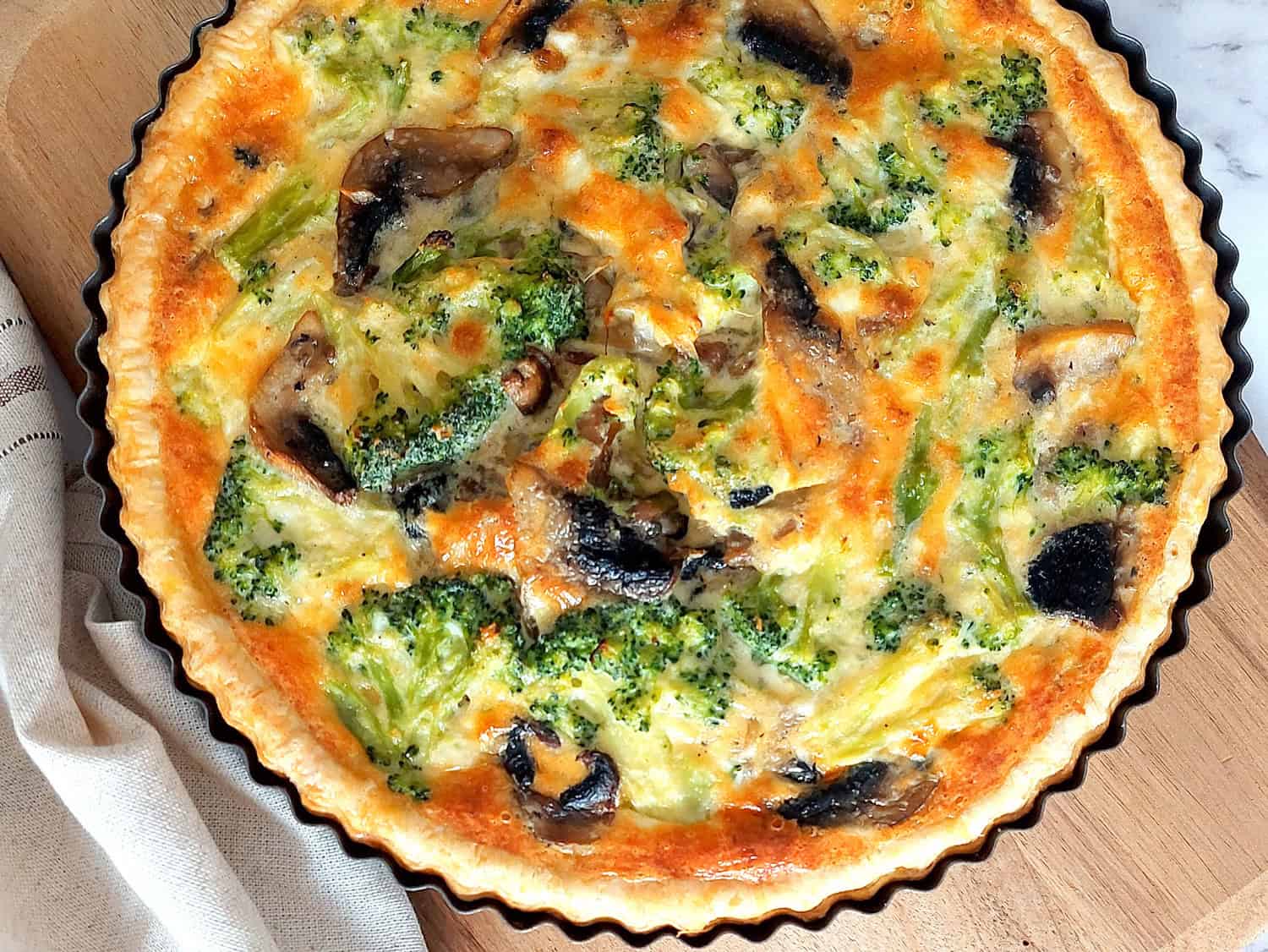 Top view of veggie quiche on a wooden board