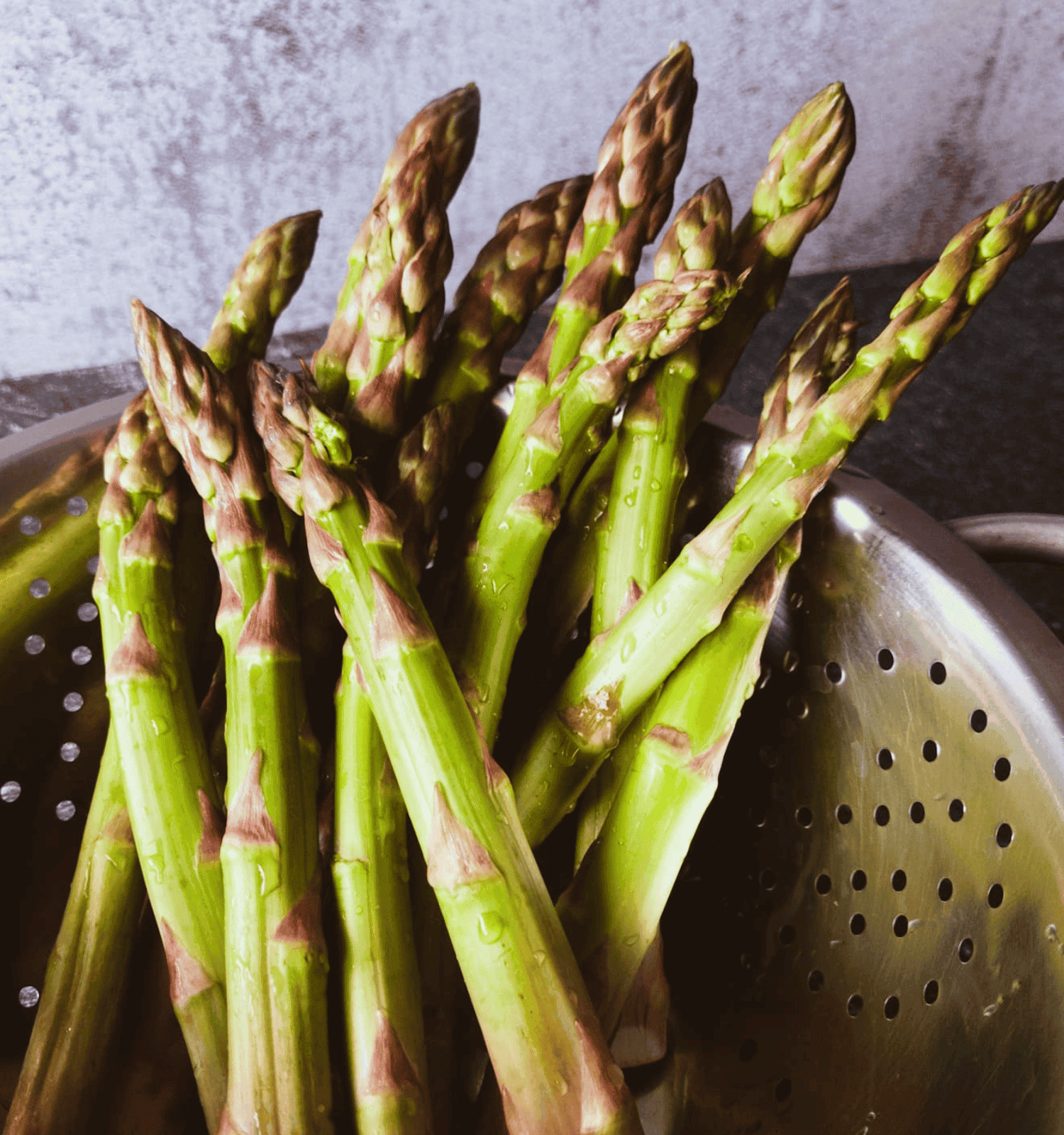 Washed asparagus spears in a colander