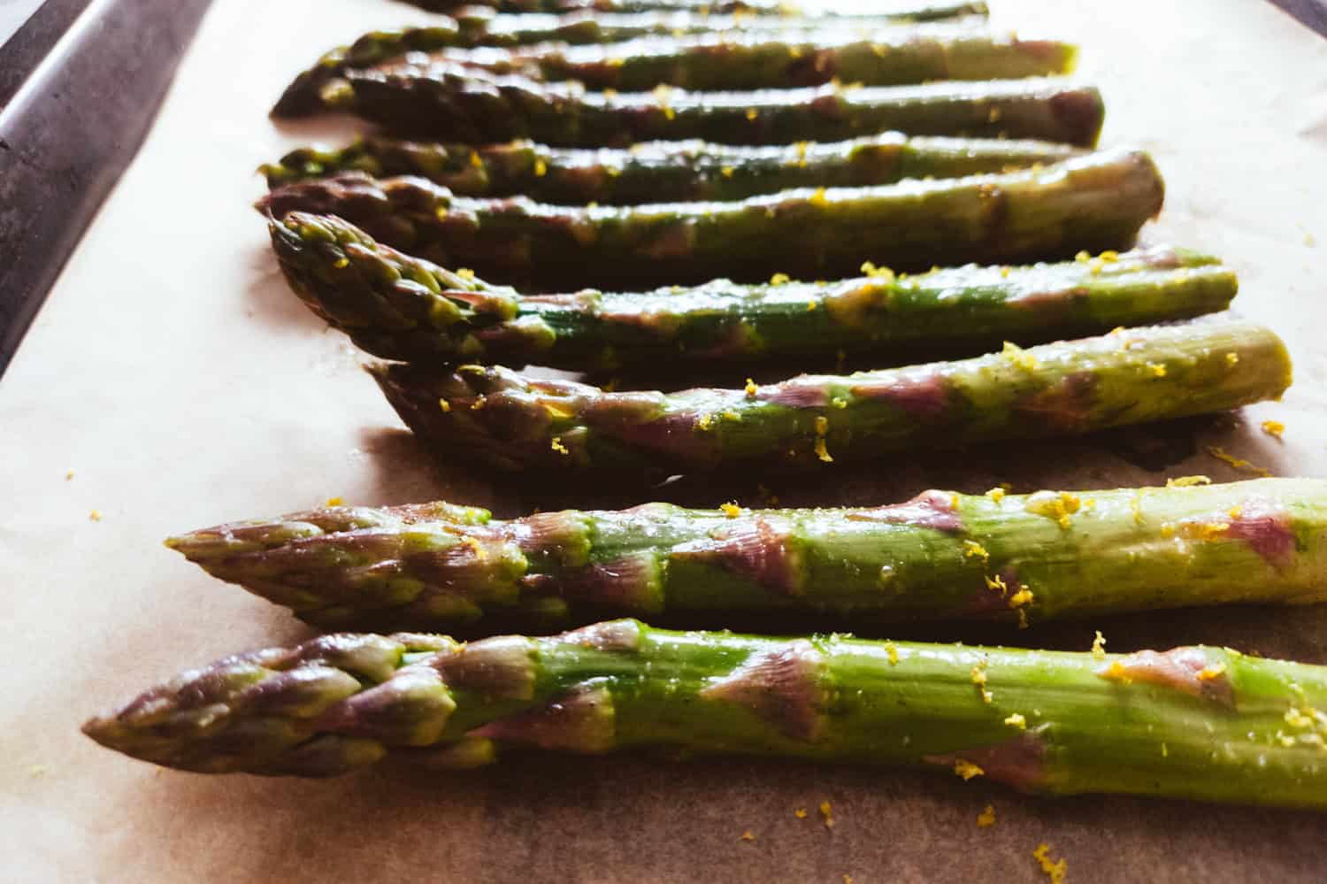 Asparagus spears lined on a baking tray
