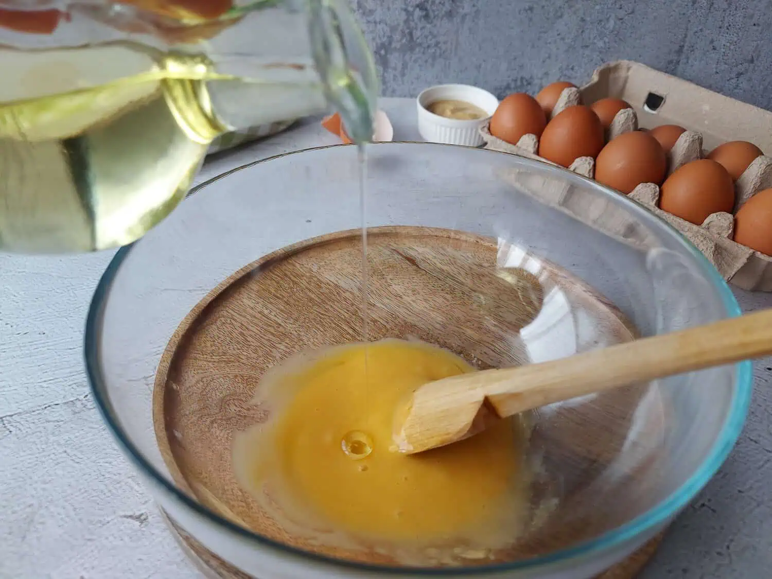 Mayonnaise in a glass bowl with a drizzle of sunflower oil
