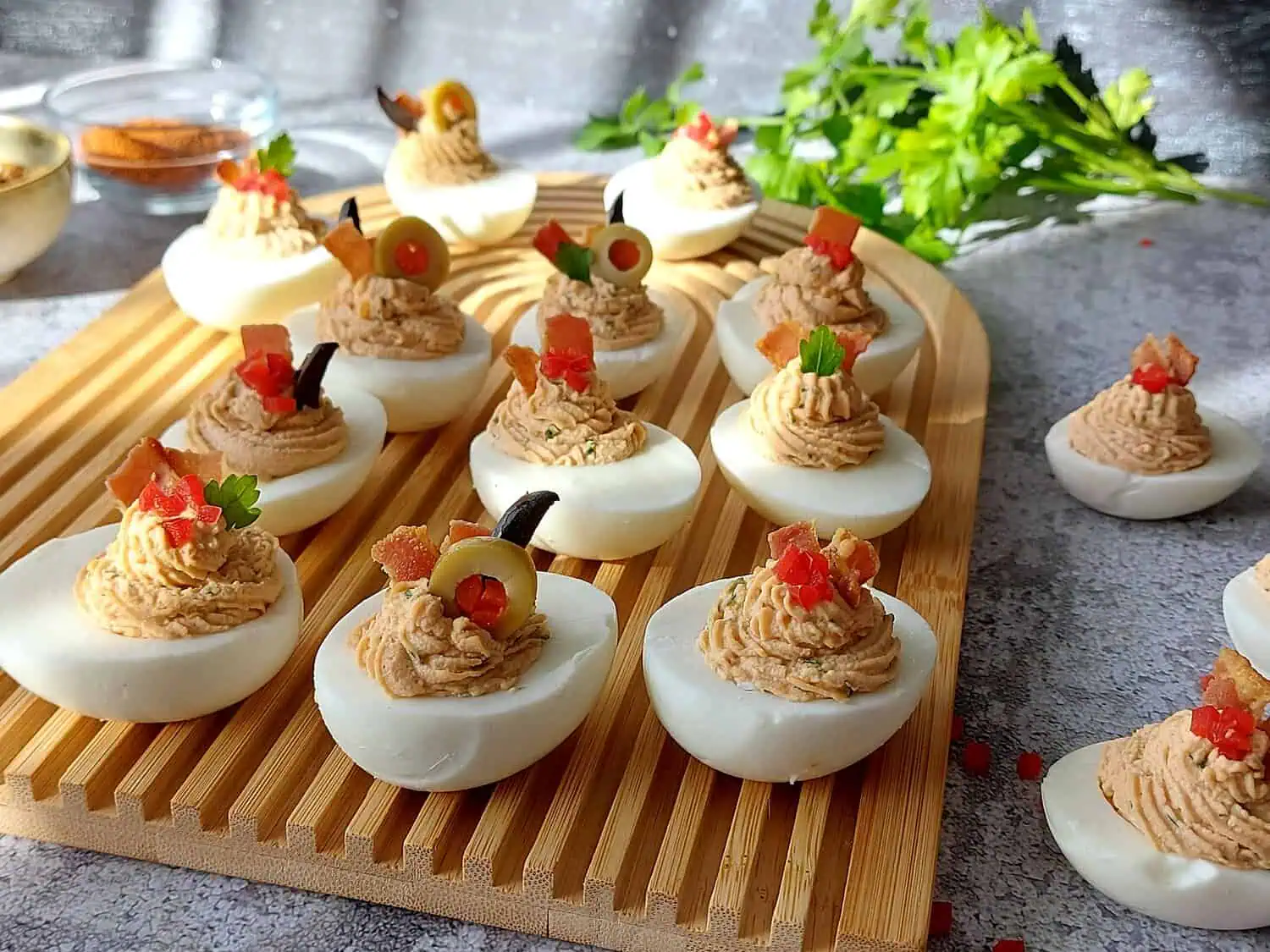 BACON DEVILED EGGS ON A WOODEN BOARD