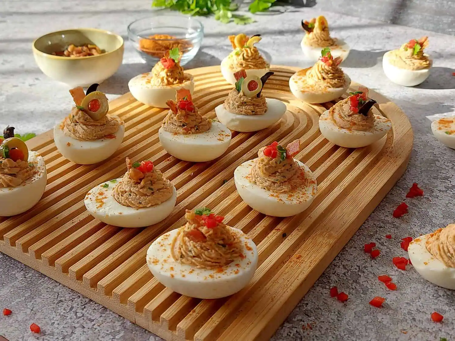 CLOSE UP OF STUFFED EGGS ON A WOODEN BOARD