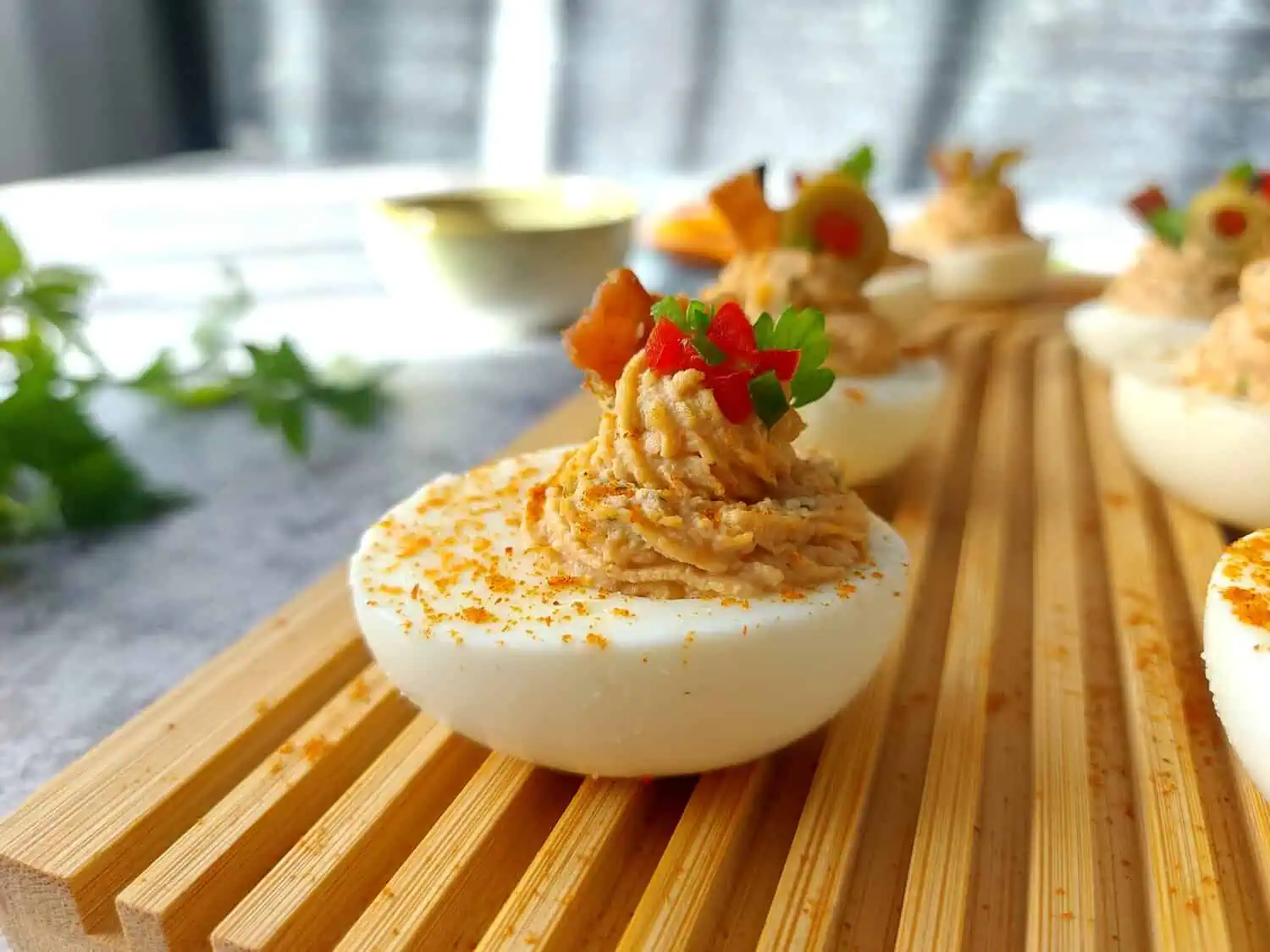 CLOSE UP OF A DEVILED EGG ON A WOODEN BOARD