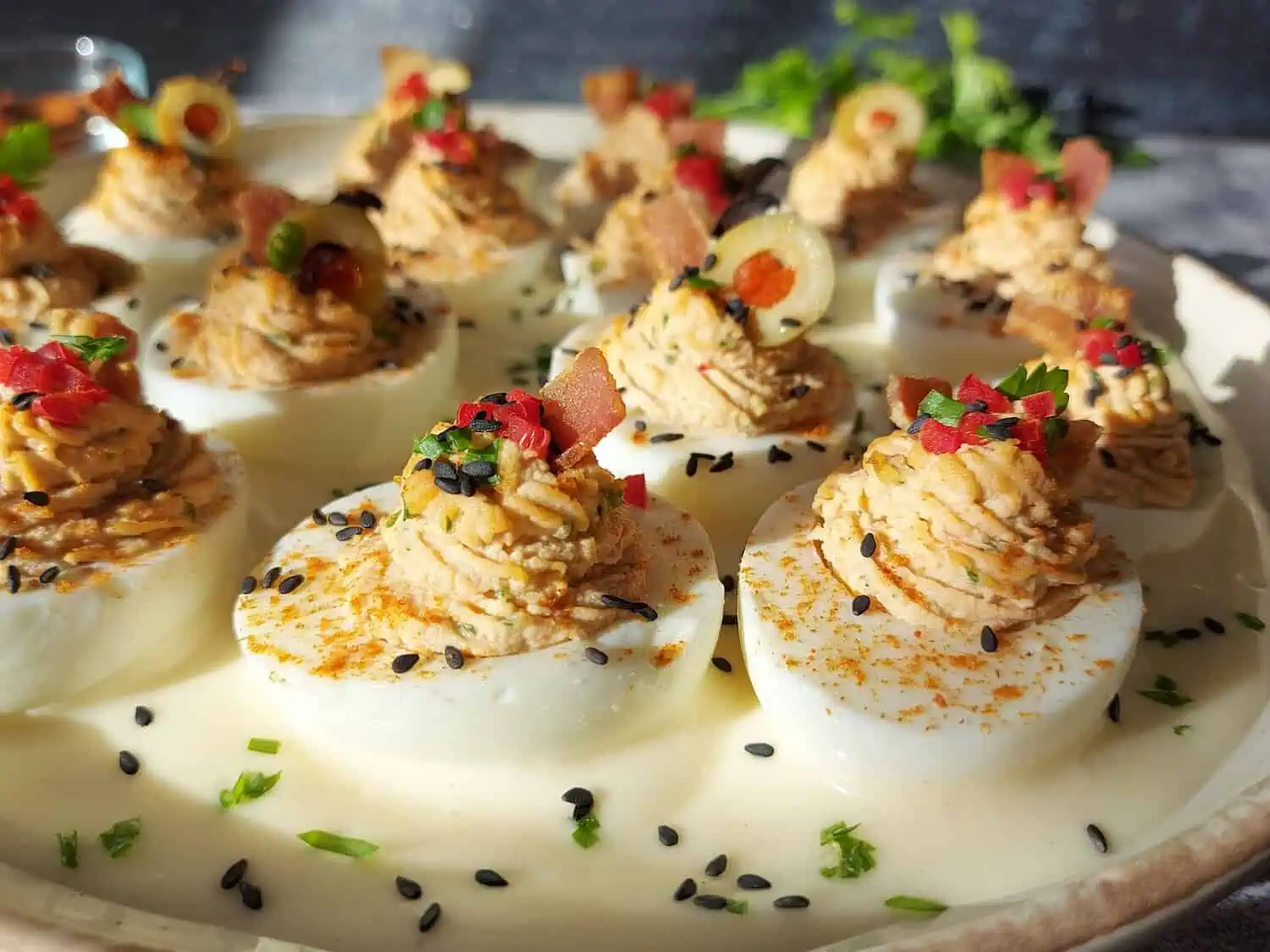 stuffed eggs with bacon on a bed of mayonnaise sauce