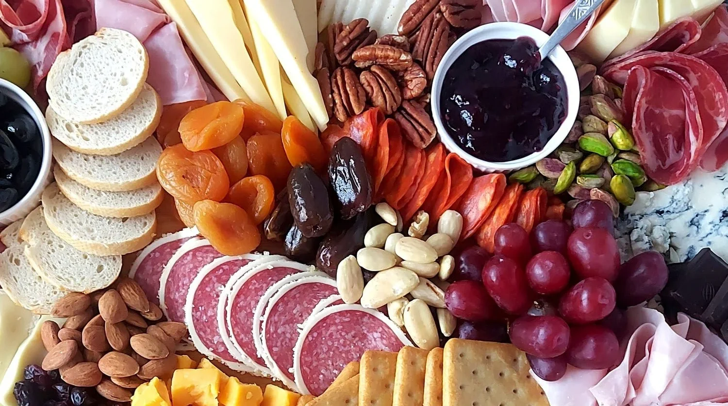 image with almonds, salami, mixed berry jam, red grapes, brazilian nuts, pecan nuts and cheese wedges