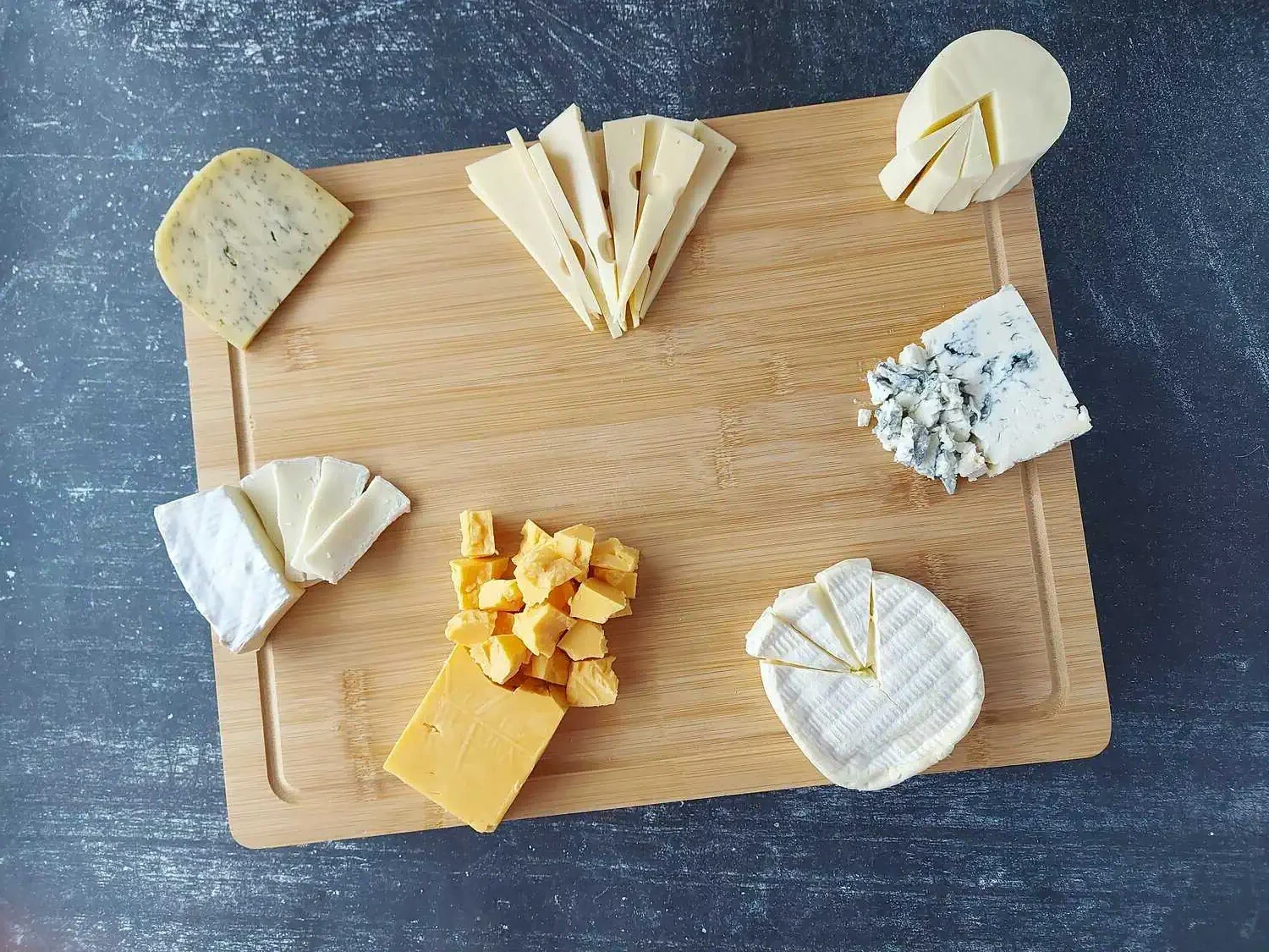 7 cheese arranged around the charcuterie board