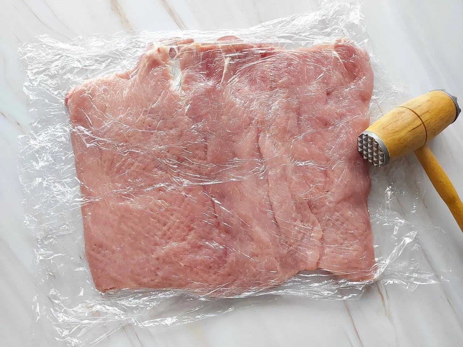 cranberry apple stuffed pork loin Flat sheet of pork loin between plastic wraps, pounded with a mallet