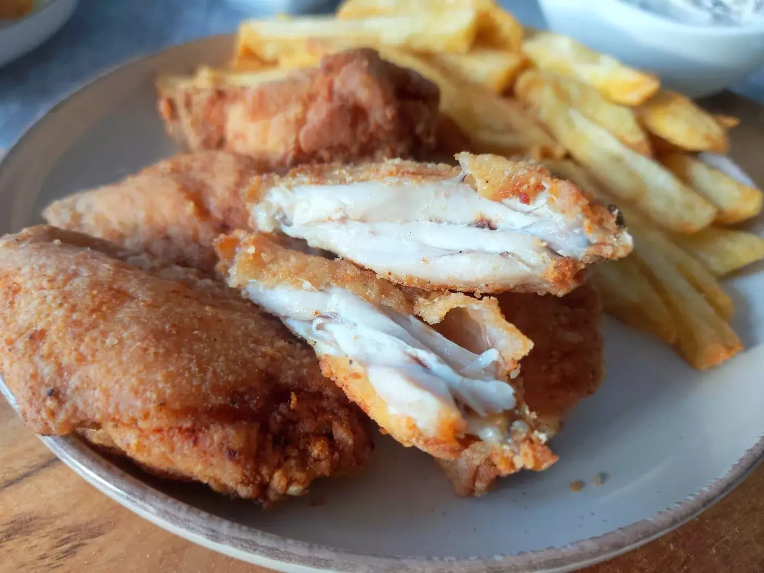 crispy fried chicken wings recipe A piece of fried chicken wing torn in two, next to some French fries