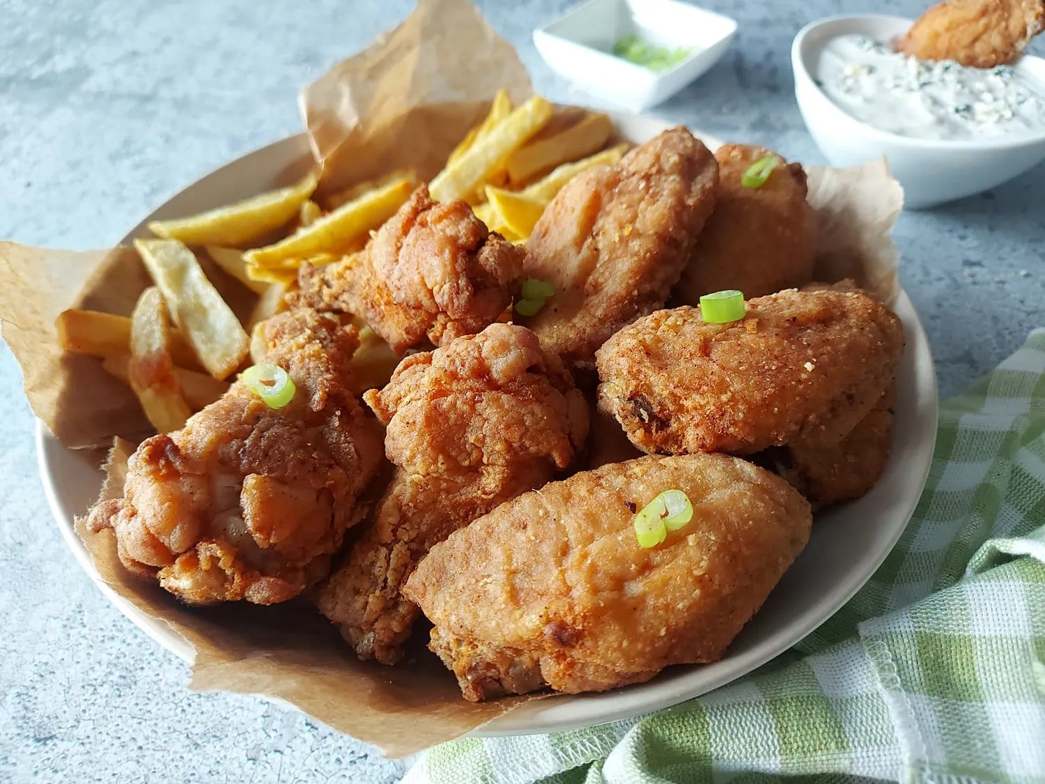 crispy fried chicken wings recipe Crispy chicken wings on a plate with blue cheese dip in the background and a green napkin