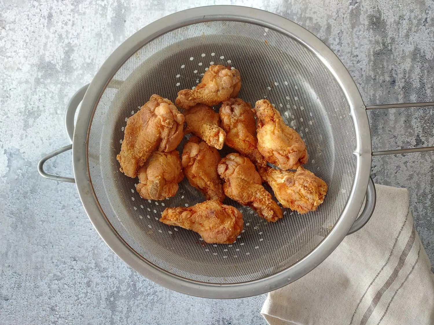 crispy fried chicken wings recipe Crispy chicken wings in a strainer over a bowl