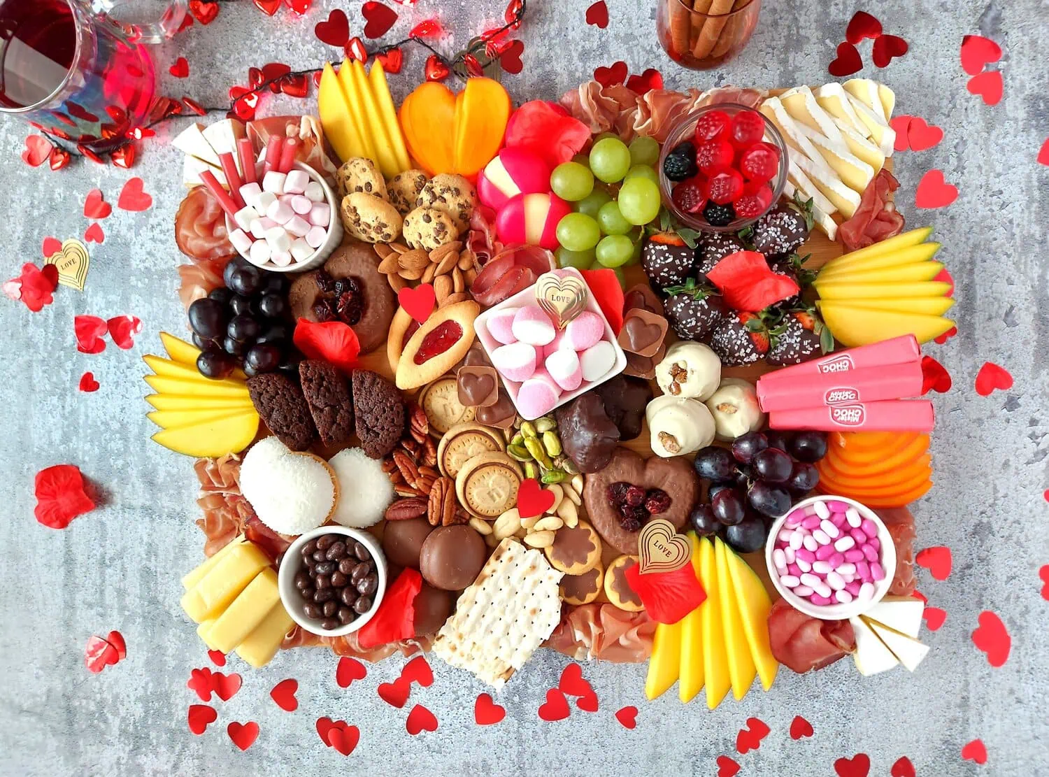 valentine's day charcuterie Sweet and savory charcuterie board with romantic finishing touches, confetti hearts and rose petals