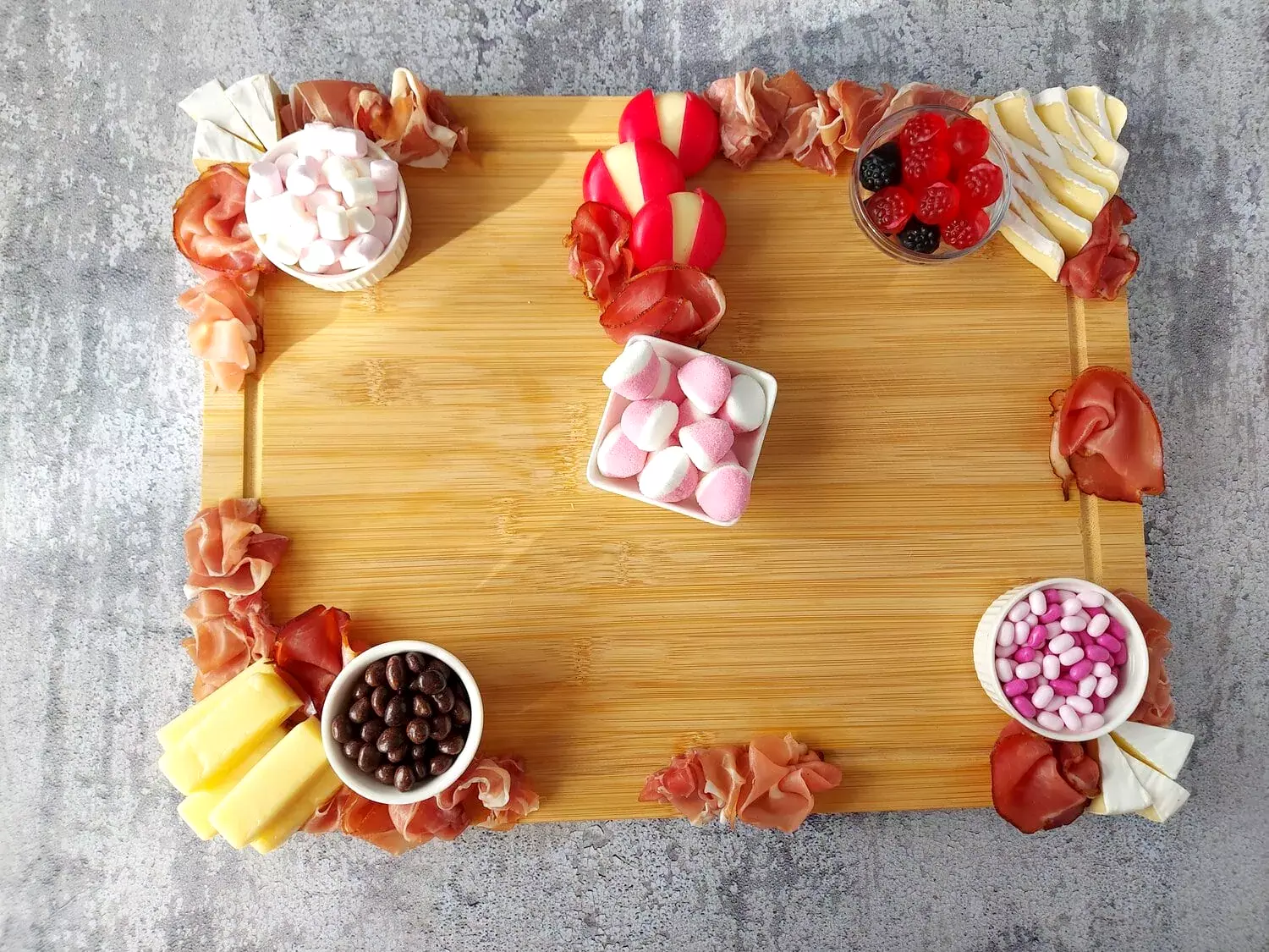 valentine's day charcuterie Valentine's Day Charcuterie board with cheeses, variety of meats and small bowls with candies and marshmallows