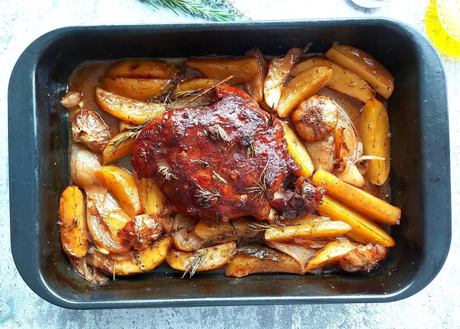 Roasted Greek slow cooked lamb in a pan with greek roasted potatoes