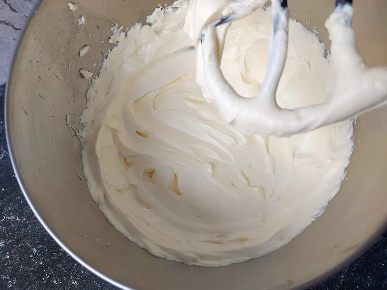 Cream cheese and mascarpone cheese beat together in a mixer bowl with a paddle attachment