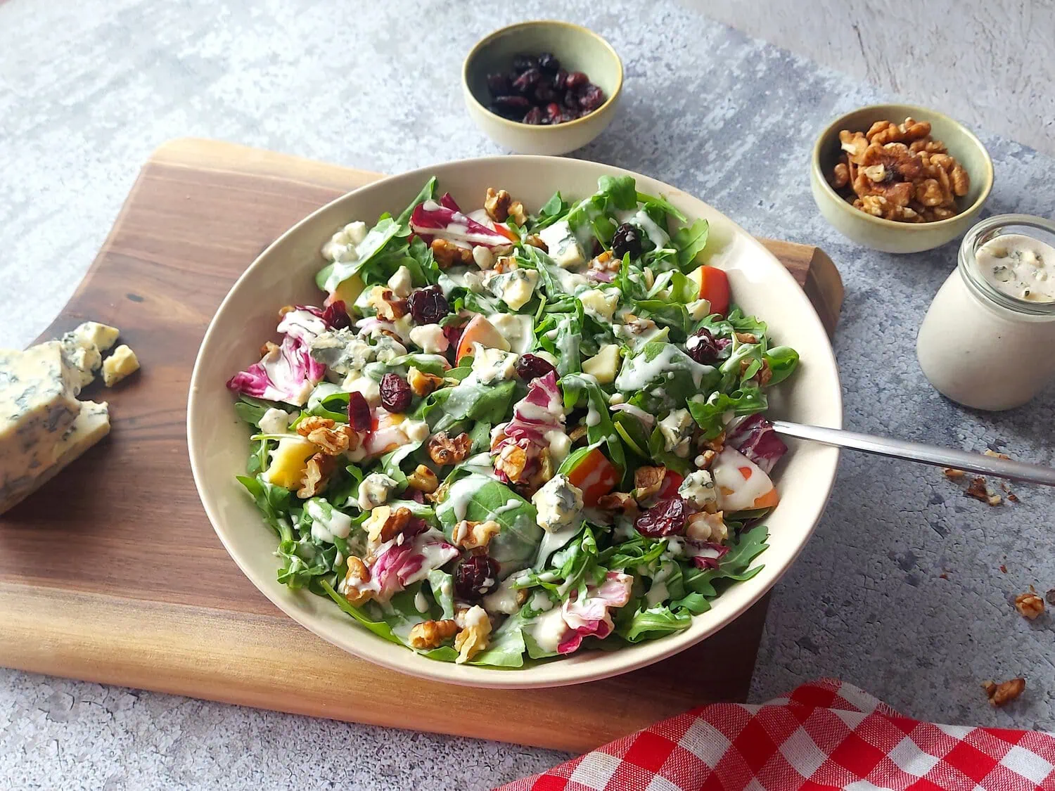 Apple walnut blue cheese salad complete on a plate with a fork