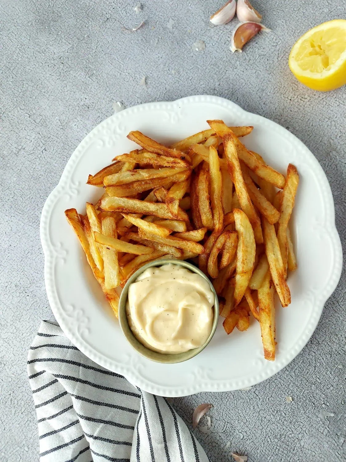 Aioli sauce on a white plate with French fries