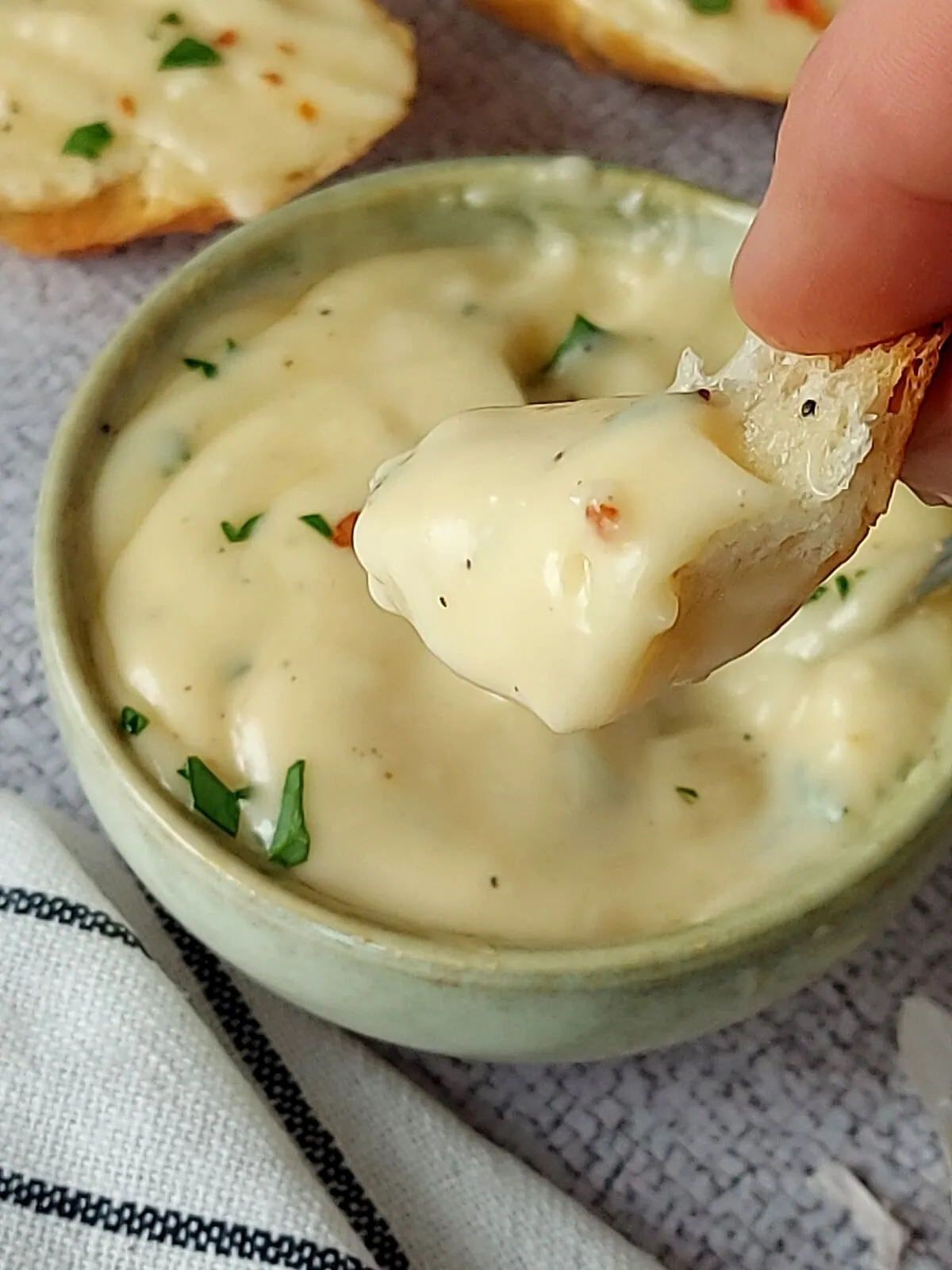 Close-up shot of a piece of bread dipped in aioli sauce