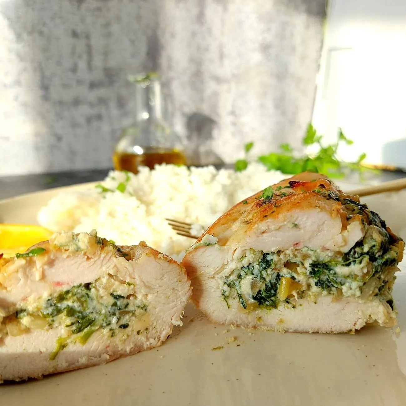 close-up shot of a chicken breast cut in half showing the ricotta spinach filling
