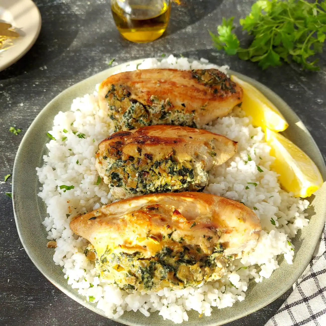 overhead shot of a place with rice topped with 3 pieces of ricotta chicken breasts served with lemon wedges