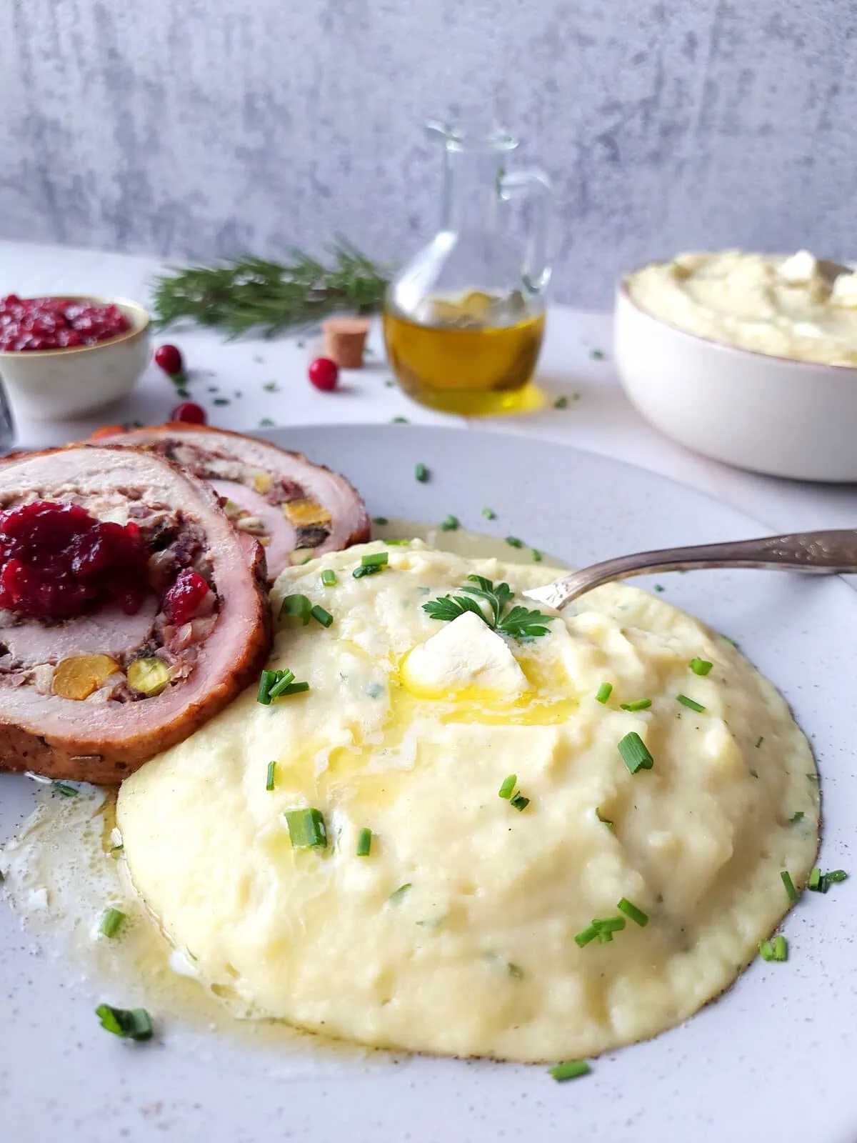 Plate with mashed cheesy mashed potatoes and apple cranberry stuffed pork loin