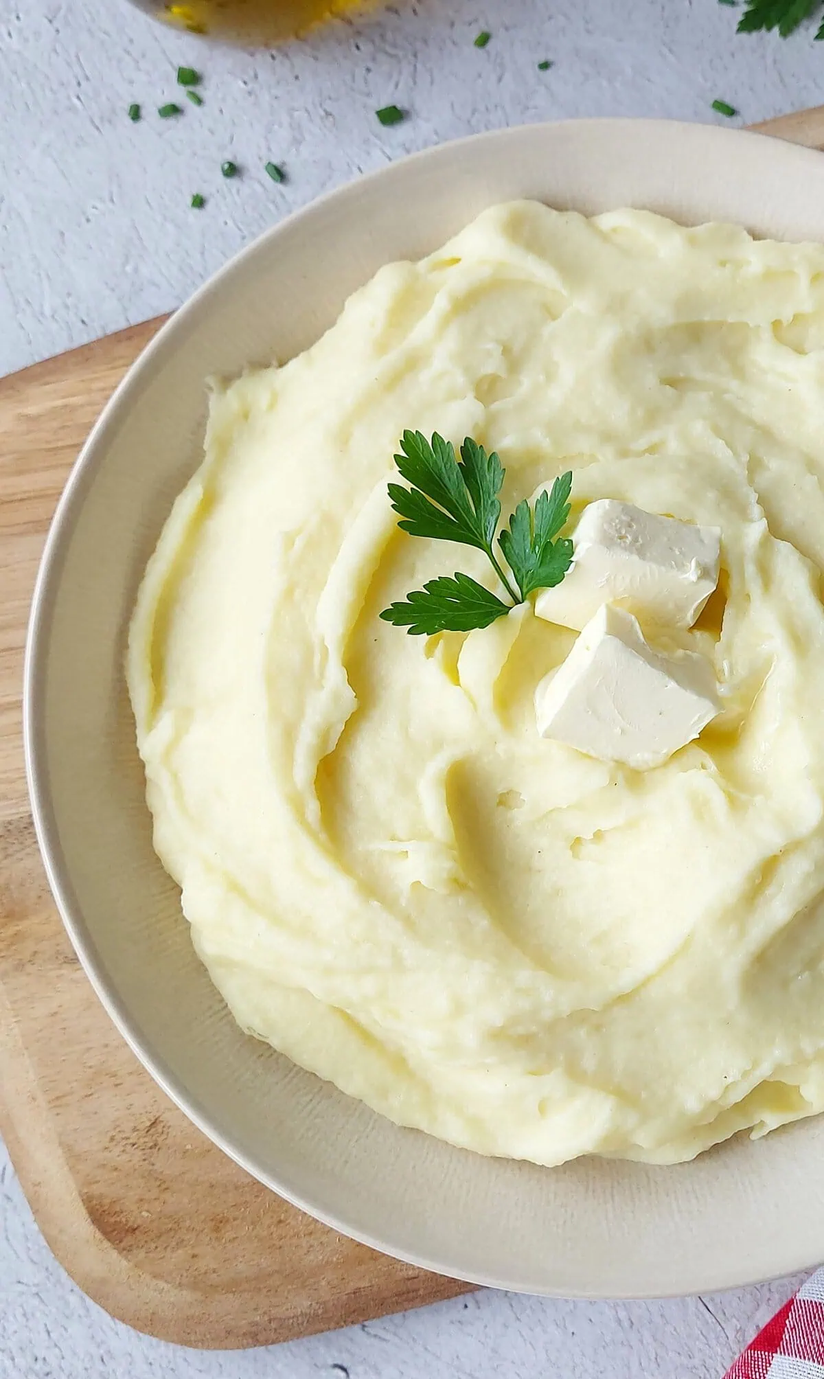 CHEESY MASHED POTATOES ON A PLATE WITH PARSLEY ON TOP