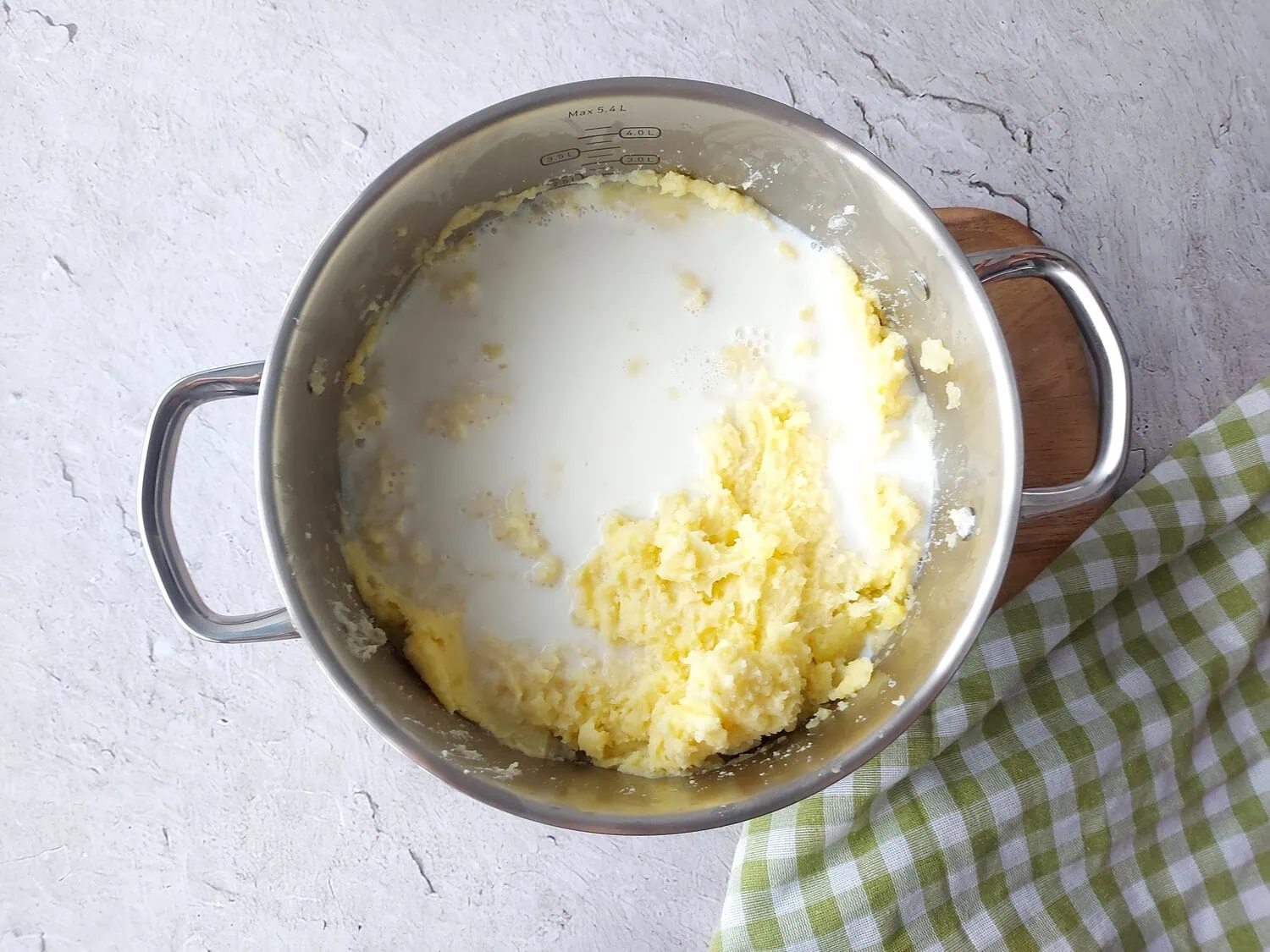 Mashed potatoes with whole milk and heavy cream in a large pot