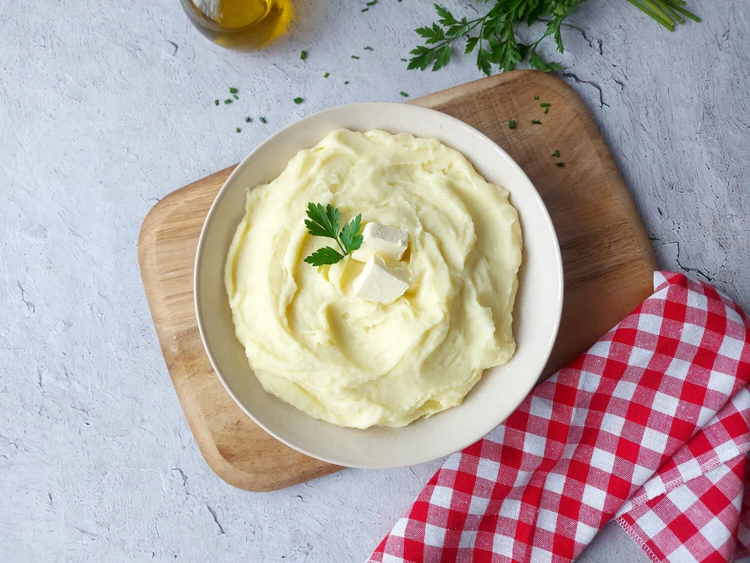 Cheesy mashed potatoes in a bowl, garnished with parsley leaves