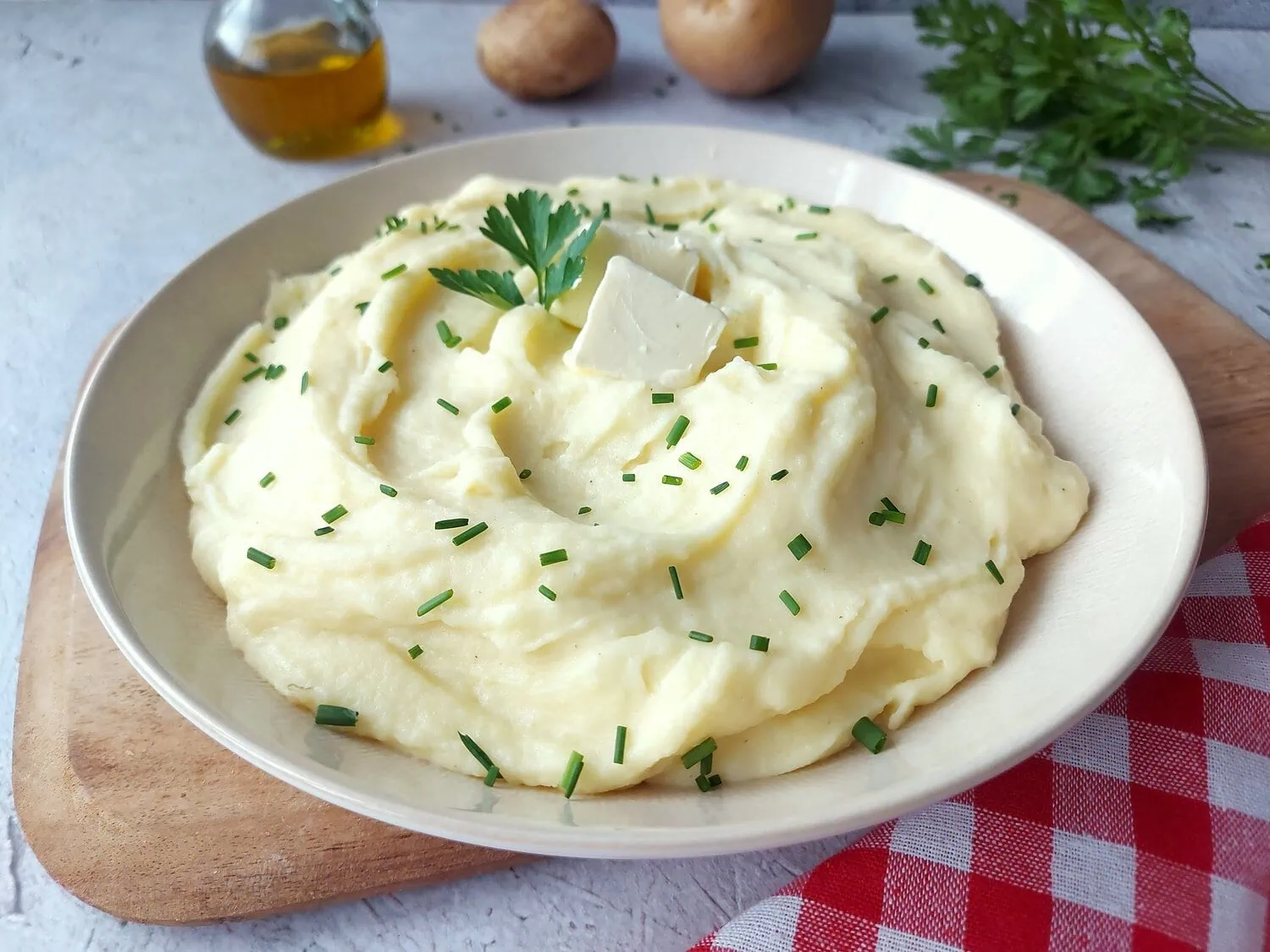 Close up shot of a plate with mashed potatoes garnished with chives