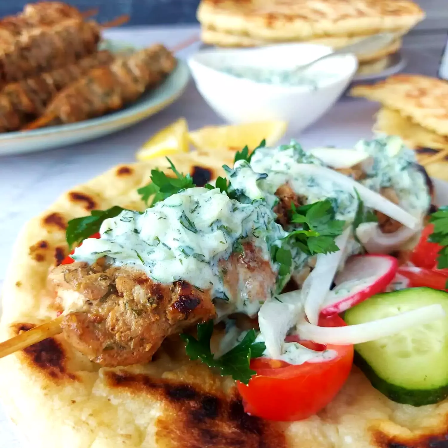 traditional greek souvlaki Pita bread with a chicken souvlaki skewer drizzled with tzatziki sauce