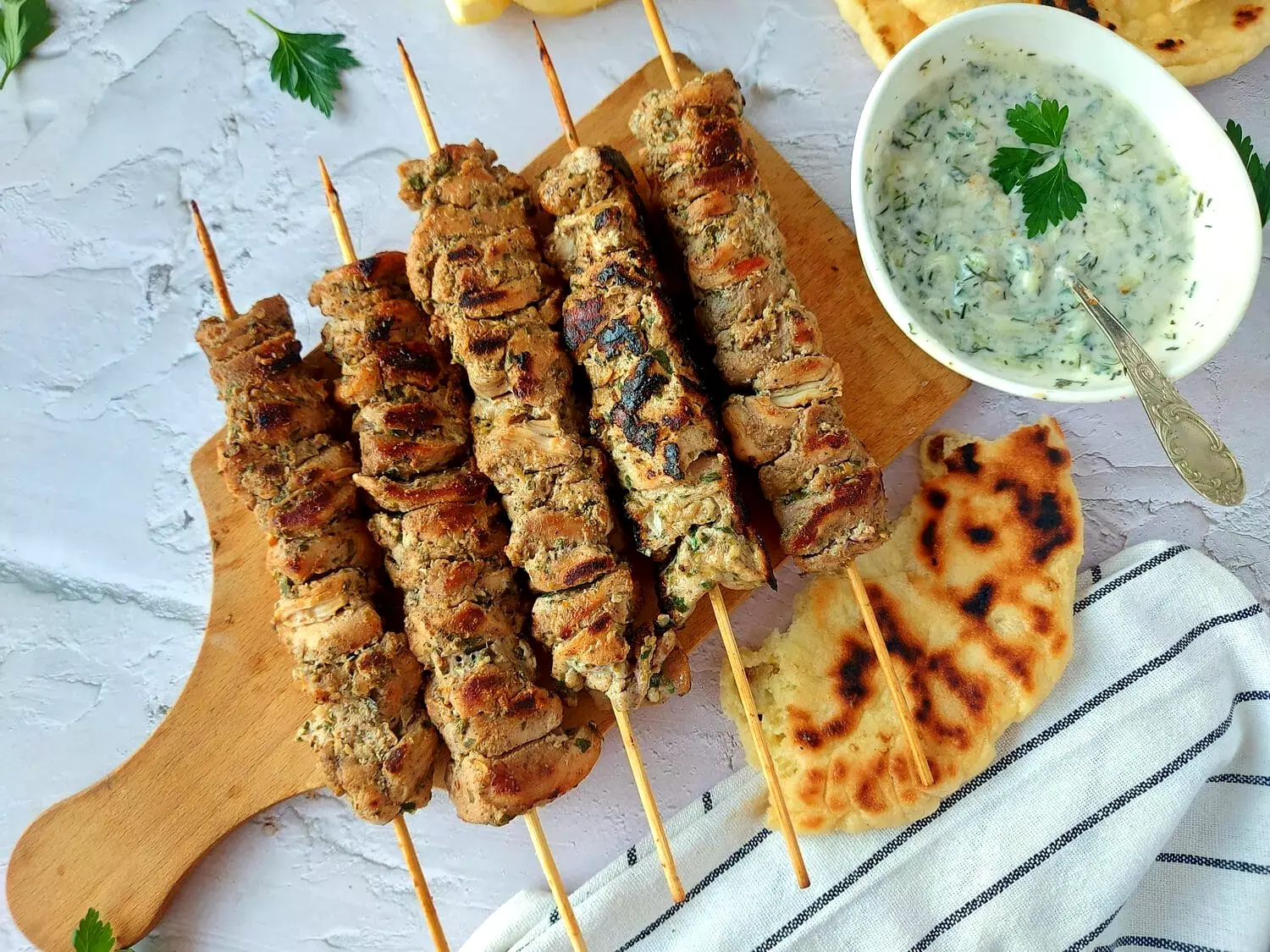 traditional greek souvlaki souvlaki chicken skewers on a board served with pita bread and tzatziki sauce