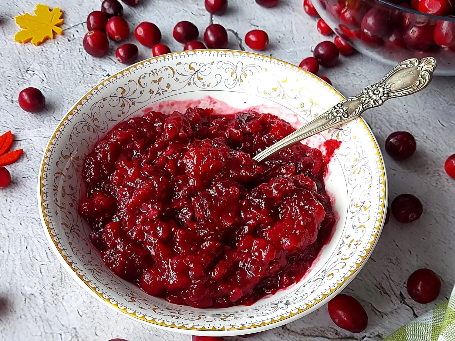 homemade cranberry sauce with orange juice Small bowl with cranberry and orange sauce, with fresh cranberries sprinkled around