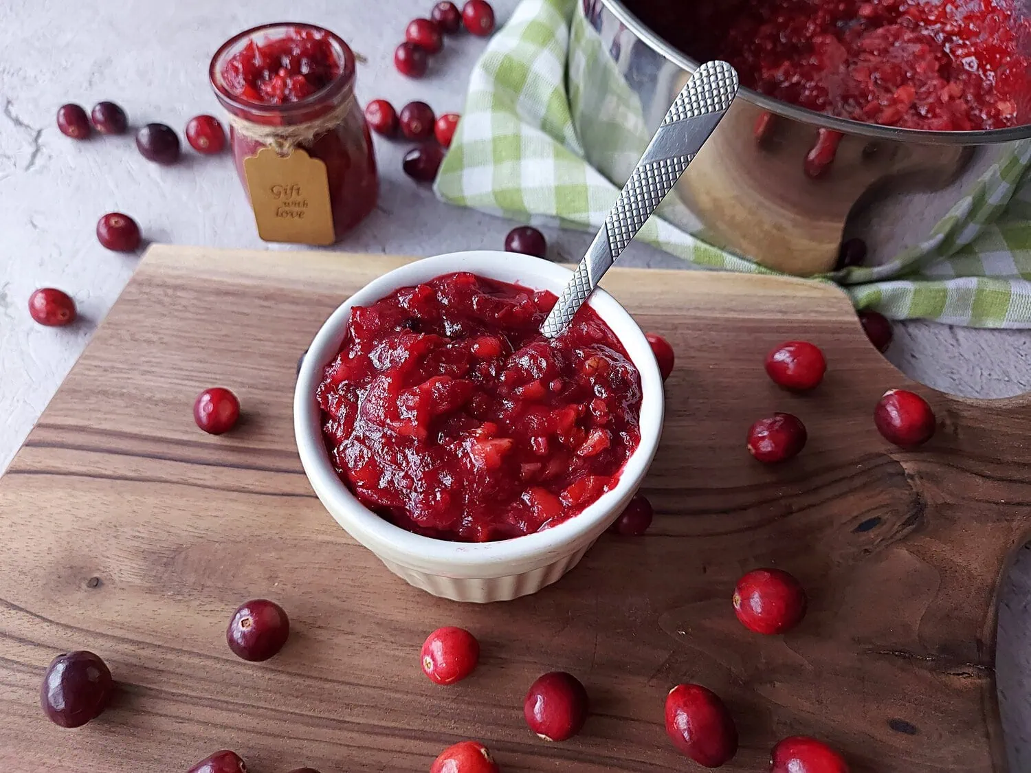 homemade cranberry sauce with orange juice HOMEMADE CRANBERRY SAUCE WITH ORANGE JUICE on a wooden cutting board